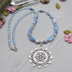 "A one of a kind, natural crystal witch aesthetic necklace featuring a beautiful flower of life, mandala pendant. This Blue Agate crystal beaded necklace was created with  blue agate, denim quartz and Vintage Czech glass beads with lead and nickel free silver accents. This boho necklace is finished with a silver plated lobster clasp and I can add an extender chain if you wish (just comment in the note to seller at checkout) At \"matinee length\" this flower of life necklace is designed to sit ju Luxury Blue Beaded Crystal Necklaces, Spiritual Agate Crystal Necklace, Spiritual Round Agate Crystal Necklace, Gemstone Flower Pendant Necklace For Healing, Bohemian Crystal Necklace With Round Gemstone Pendant, Silver Beaded Necklace With Flower Pendant As Gift, Spiritual Agate Crystal Necklace With Round Pendant, Spiritual Agate Round Pendant Crystal Necklace, Handmade Spiritual Jewelry With Flower Pendant