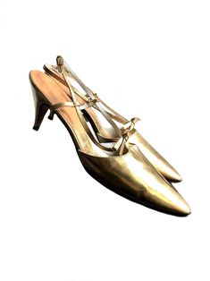 "vintage late 1950s to early 1960s gold leather pumps a beautiful pair of 50s 60s stiletto heels made of super soft genuine leather with a gold metallic finish. they are adorned with a little gold leather bow and designed with a long pointy nose and adjustable heel strap. stamped size : US 7 1/2 AAA  (modern size 7) brand: J. Miller in excellent vintage condition, minor wear on the bottom soles, very minimal scuff marks on the heels. the gold leather feels incredible soft and is in great conditi Pointy Pumps, Leather Bows, Gold Leather, Leather Pumps, Vintage Shoes, Strap Heels, Women's Pumps, 1960s, Stiletto Heels