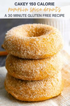 three sugared donuts stacked on top of each other next to a coffee cup