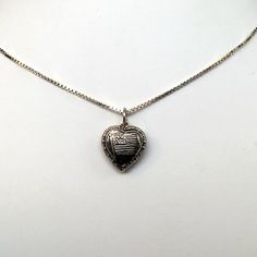 "This antiqued sterling silver, two-sided, repousse Puffy heart Charm Number 33 features an American flag framed by an heart. Marked, Sterling. Made by Brown County Silver. Vintage and in new, never worn condition. Approximately 30 years old. Small: 5/8\" high with jump ring 3/8\" wide 0.7 grams Medium: 7/8\" high with jump ring 5/8\" wide 1.4 grams *Chain sold separately See more @ https://www.etsy.com/shop/brocosi" Silver Etched Necklace For Valentine's Day, Valentine's Day Silver Etched Necklace, Silver Sterling Heart Necklace For Memorial, Silver Heart Necklace For Commemoration, Antique Silver Engraved Heart Jewelry, Etched Heart Silver Necklace, Silver Heart-shaped Etched Necklace, White Gold Heart Charm Jewelry For Memorial, Antique Silver Engraved Jewelry For Valentine's Day