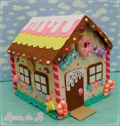 a cake shaped like a house with candy on the roof and decorations around the windows