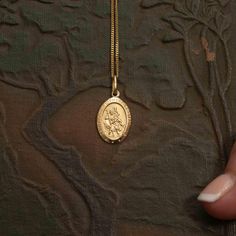 Discover the exquisite beauty of our 10k gold oval Saint Christopher pendant, a symbol of protection for travellers. This stunning pendant features a detailed 3D design of Saint Christopher carrying a child on his shoulder, representing his revered role as the Patron Saint of travel. The pendant measures 16mm in length (excluding the jump ring) and 12mm in width, making it a perfect size to wear as a statement piece or to layer with other cherished necklaces. Crafted with meticulous attention to St Christopher Pendant, Saint Christopher, Canada Post, Patron Saints, Oval Pendant, Elegant Necklaces, Jump Rings, 10k Gold, 3d Design