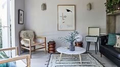 a living room filled with furniture next to a wall mounted planter and potted plants