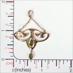 "This gorgeous Art Nouveau pedant has a touch of Egyptian revival flare. With it's floral motifs and bright sparkling spring green Peridot gems, this lovely piece has wonderful lines that make me long for warm days in the garden. This hand crafted pendant was made in England in about 1900. The two peridots add up to about .65 carats. The pendant measures 46.2 mm across and 32.2 mm top to bottom (26.8 mm not including the chain), it weighs 1.6 grams. Thanks! If you like this piece and would like Antique Yellow Gold May Birthstone Jewelry, Antique Yellow Gold Jewelry For May Birthstone, Art Nouveau 14k Gold Jewelry With Intricate Design, 14k Yellow Gold Art Nouveau Jewelry, Art Nouveau Yellow Gold Jewelry With 17 Jewels, Art Nouveau Yellow Gold Pendant Jewelry, Antique Peridot Gemstone Jewelry, Green Marquise Hallmarked Jewelry, Heirloom Style Green Filigree Jewelry