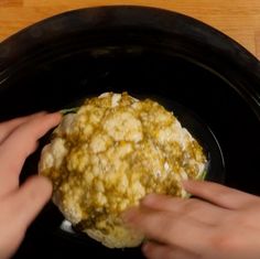 two hands reaching for food in a crock pot