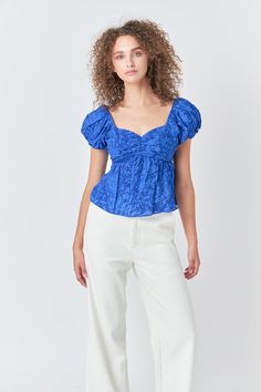 The sweetest way to top off your look. This woven floral top is feminine and sweet with a touch of flirtation. With its short puff sleeves and darling details, this top will have you looking elegant for any occasion. We love the off-shoulder style which gives a peek of skin, while the back tie detail adds just the right touch of intrigue. Woven floral fabrication Sweetheart neckline Short puff sleeves Optional off-shoulder Cut-out back detail Back tie detail Shell: 100% CottonLining: 85% Polyest Spring Fitted Puff Sleeve Top With Short Sleeves, Fitted Short Sleeve Puff Top For Spring, Spring Day Out Fitted Puff Sleeve Top, Feminine Fitted Puff Sleeve Top For Summer, Chic Fitted Smocked Top With Short Sleeves, Spring Off-shoulder Fitted Blouse, Chic Fitted Short Sleeve Smocked Top, Elegant Off-shoulder Top With Smocked Bodice, Flirty Off-shoulder Tops For Brunch