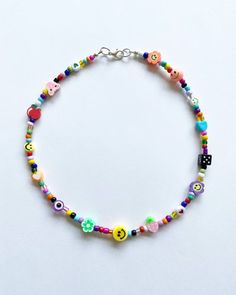 a colorful beaded bracelet with smiley faces and hearts on the clasp is shown against a white background