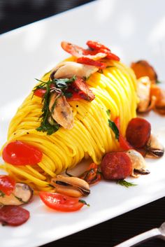 a pasta dish on a white plate with mushrooms and peppers