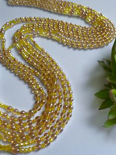 Double Strand Waist Bead, featuring vibrant yellow crystal glass beads with elegant brown and gold accents. Why You'll Love It: Radiant Shine: Beautiful yellow crystal glass beads offer a lively, eye-catching sparkle. Elegant Accents: Brown and gold crystal glass beads add a touch of sophistication and warmth. Perfect Fit: The adjustable double strand design ensures a comfortable and secure fit for all body types. Cultural Elegance: This piece captures the rich heritage of Ivorian craftsmanship, blending traditional beauty with modern flair. Color Significance: Yellow: In Ivorian culture, yellow symbolizes happiness, energy, and vitality. Wearing yellow beads can uplift your spirit and bring a sense of joy and warmth. Brown: Brown represents the earth, stability, and reliability. It adds g Gold Beads With Beaded Chain For Party, Gold Beaded Chain Beads For Party, Gold Beaded Crystal Necklaces, Gold Beaded Chain For Party, Gold Crystal Necklaces With Faceted Beads For Party, Yellow Crystal Necklace For Party, Yellow Multi-strand Polished Beaded Necklaces, Gold Beaded Necklaces With Polished Beads For Party, Gold Multi-strand Beaded Necklaces With Faceted Beads