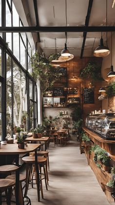 the inside of a restaurant with lots of tables and stools, plants hanging from the ceiling