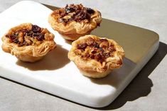 three small pastries sitting on top of a cutting board