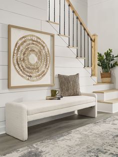 a white bench sitting under a stair case