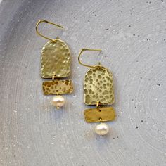 Abstract brass earrings in geometric design with fresh water pearls. The chandelier earrings are extra sparkly thanks to it's hammered texture. These modern pearl earrings are very light weighted and ideal for everyday wear. The 1mm brass wire is very stable and i sanded down the ends for a comfortable application. DETAILS: - brass  - fresh water pearls - app. 5,5cm x 1,8cm/ 2" x 0,7" Herstellerin/ Manufacturer Christine Hornicke, Finkenberg 64, 23558 Lübeck, Germany hello@gudbling.com Back to m Handmade Brass Dangle Earrings, Delicate Handmade Brass Earrings, Handmade Modern Brass Earrings, Artisan Brass Drop Earrings, Contemporary Handmade Brass Earrings, Modern Pearl Earrings, Lapidary Jewelry, White Tassel Earrings, Silversmithing Jewelry