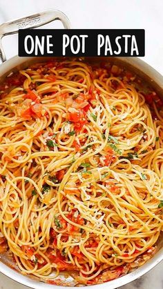 a pan filled with pasta and sauce on top of a marble counter