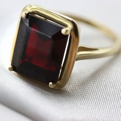 An Absolutely gorgeous Red Garnet Gold ring. Featuring a Prong set 6.5 Carat 10 x 12 Red Garnet natural Gemstone. The color is simply amazing as well as the clarity, This is a Grade AAA corundum Gemstone. When i saw the beauty of this gemstone i had to have it, I simply had to buy a few and make a few rings with them i could not escape its beauty! Each ring is hand made to your order from start to finish with the utmost attention to details, service and finish. We only have a few of these marvel Fine Jewelry Garnet Ring With Prong Setting, Garnet Rings With Prong Setting In Fine Jewelry Style, Formal Open Ruby Ring With Gemstone, Classic Red Sapphire Promise Ring, Classic Red Birthstone Ring, Formal Ruby Open Ring, Formal Red Rings, Fine Jewelry Garnet Solitaire Ring, Fine Jewelry Garnet Rings Hallmarked