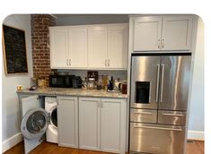 a kitchen with white cabinets and stainless steel appliances, including a washer and dryer