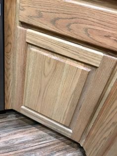 the corner of a kitchen cabinet door with wood grain pattern on the bottom and sides