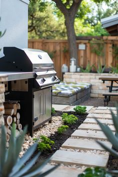 an outdoor bbq grill in the middle of a garden