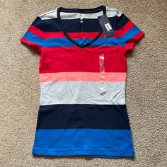 New With Tag! This Uber Soft Cotton T-Shirt Is Part Of The Formula One Core Items Collection From Tommy Hilfiger. Features A V-Neck And Multi-Colored Stripes Including Blue, Red, Salmon, Heather Gray, And Navy. Additional Details: V-Neck T-Shirt Tommy Logo On Left Chest 100% Cotton Machine Wash Sporty Striped V-neck Top, Striped Stretch V-neck Top, Striped Cotton V-neck T-shirt, Summer Striped Tops By Tommy Hilfiger, Tommy Hilfiger Striped Tops For Summer, Casual Striped V-neck Top, Tommy Hilfiger Striped Tops For Spring, Tommy Hilfiger Blue Summer T-shirt, Tommy Hilfiger Stretch Top For Spring