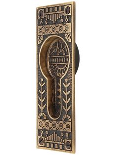 a door handle with an ornate design on the front and back panel, in brass