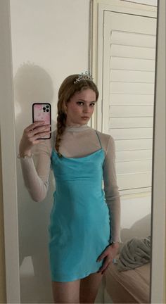 a woman in a blue dress taking a selfie