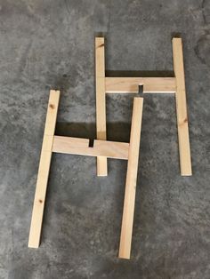 two pieces of wood sitting on top of a cement floor with one piece missing from the frame