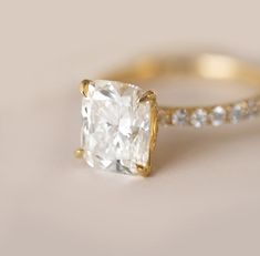 Truly one of our favorite looks of all time! A big diamond set in a petite pave diamond band - say no more 😉. We setup this ring with such a desirable shaped diamond - a magnificent 3.02 ct. lab grown elongated cushion diamond that sparkles to perfection. The diamond has zero-bow effect, perfect proportions and is incredibly bright. 3.02 ct. lab grown cushion cut diamond Color H and Clarity VS1 IGI certified 0.54 cttw. natural brilliant cut diamonds 18K yellow gold We proudly offer both natural Cushion Cut Diamond Ring, Pave Diamond Engagement Rings, Elongated Cushion, Pave Diamond Band, Cushion Cut Moissanite, Cushion Cut Diamond, Pave Engagement Ring, Big Diamond, Bridal Ring Sets