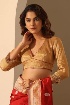 Golden tissue silk blouse with rust piping and kiran lace hand embroidered sleeves.
Components: 1
Pattern: Hand embroidered
Type Of Work: Kiran lace
Neckline: Deep V Neck
Sleeve Type: Three quarter
Fabric: Tissue silk
Color: Gold
Other Details: 
Model Height : 5 ft 6 inches, wearing size S
Note : Saree worn by the model is not for sale.
Occasion: Wedding - Aza Fashions Gold Blouse, Embroidered Sleeves, Durga Puja, Lace Neckline, Blouse For Women, Blouse Design, Embroidered Blouse, Saree Blouse, Deep V Neck