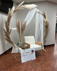 a white chair sitting next to a sign on top of a hard wood floor in an office