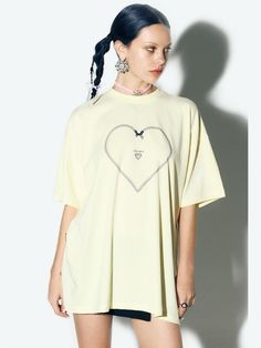 This clothing features a t-shirt with a short-sleeve design and a round neckline. The shirt features a large, heart-shaped graphic outlined with a chain-like design, centered on the chest area. Within the heart, there's a smaller heart with wings and the word CANDYFORNIA written inside it, suggesting a brand or theme. The contrast of the white graphic on the fabric creates a bold, graphic look.- The heart with wings motif gives the shirt a playful and youthful feel.- The chain outline of the heart adds a touch of edginess to the otherwise simple t-shirt.- The overall design is trendy and would likely appeal to a fashion-forward demographic looking for statement casual wear. Spring Streetwear T-shirt With Heart Graphic, Oversized Heart Graphic T-shirt With Crew Neck, Oversized Heart Graphic Crew Neck T-shirt, Oversized Crew Neck T-shirt With Heart Graphic, Oversized Heart Graphic Top For Streetwear, Oversized Tops With Heart Graphic For Streetwear, Oversized Heart Graphic T-shirt For Streetwear, Heart Graphic T-shirt For Spring Streetwear, Spring Heart Graphic T-shirt For Streetwear