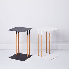 two black and white tables sitting next to each other on top of a white floor