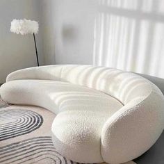 a white couch sitting on top of a rug next to a window