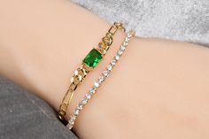 This listing is for the bracelet with the emerald green stone only. Please see below for the tennis bracelet shown in the 1st picture. Dainty gold plated chain bracelet, made with a delicate Figaro chain, attached to a slightly larger cuban chain section with an emerald-cut emerald stone in its center. Please select bracelet size from the drop down menu. COMPONENTS: Chain - gold plated. Clasp - 14k gold filled. Emerald stone - 8x5mm, emerald cubic zirconia. Your item will arrive in a beautifully Green Emerald Bracelets For Party, Green Gold-plated Chain Bracelet As A Gift, Green Gold-plated Chain Bracelet Gift, Green Gold Plated Chain Bracelet Gift, Green Gold Plated Chain Bracelet As Gift, Elegant Green Chain Bracelet As Gift, Elegant Green Chain Bracelet Gift, Emerald Cut Tennis Bracelet As Gift, Elegant Green Jewelry With Gold Chain