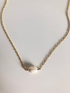 In the Philippines pearls are a national gem! They represent the richness of beauty the stunning sea life brings to the islands. A simple single pearl sits in the center of this gold filled chain. 15" long. White Single Strand Pearl Necklace With 14k Gold Filled, Gold Pearl Pendant Necklace In 14k Gold Filled, Gold Single Strand Dainty Pearl Necklace, Gold Charm Necklaces With Pearl Pendant, Baroque Pearl Chain Shell Necklace As A Gift, Delicate Gold Single Strand Pearl Necklace, Elegant Gold Shell Necklace With Pearl Drop, Gold Baroque Pearl Necklace With Delicate Chain, Gold Pearl Shell Necklace With Pearl Drop