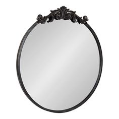 a round mirror with an ornate design on the top and bottom half, in black