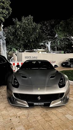 a silver sports car parked in front of a fountain