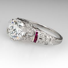 This beautiful contemporary Art Deco style platinum diamond and ruby accented mounting holds an IGI certified lab grown diamond that grades F in color and VS1 in clarity with an excellent cut grade. The ring is currently a size 7.25. EraGem lab diamond rings will arrive with an in-store certification as well as the IGI report and a lovely EraGem logo presentation box. Gia Certified Classic Ruby Ring With Diamond Accents, Luxury White Ruby Ring With Brilliant Cut, White Ruby Ring With Vvs Clarity, Exquisite Brilliant-cut Ruby And Diamond Ring, Classic White Ruby Ring With Vvs Clarity, Exquisite Ruby Ring With Brilliant Cut Diamond, Vvs Clarity Ruby Ring With Diamond, Exquisite Ruby Ring With Diamond In Round Cut, Exquisite Ruby Ring With Diamond Round Cut