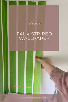 a woman is painting the wall with green and white stripes