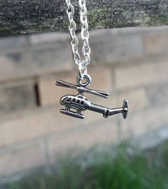 This cute helicopter necklace would make a great gift. The helicopter and chain are a silver color. The charm measures 3/4 inch and you can choose the length of the necklace. This would make a great gift for a birthday, an anniversary, Christmas or any other occasion. All jewelry items come in a gift box. Personalized Silver Charm Necklace, Adjustable Themed Silver Charm Necklaces, Themed Silver Necklace For Birthday, Silver Charm Necklace With Adjustable Chain For Birthday, Silver Themed Necklace For Gift, Themed Silver Necklace For Gift, Silver Adjustable Charm Necklace For Birthday, Silver Metal Charm Necklace For Birthday, Silver Charm Necklace For Birthday Gift