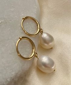 ❀Pearl❀ Earrings  Dress your ears in pure elegance with our Gold-Plated Sterling Silver Freshwater Pearl Drop Earrings! 🌟✨ Delicate and dainty, these beauties add a touch of sophistication to any look. The lustrous pearls dance with every step, making you the star of the show. Shine on, you glamorous pearl lover!   ♥ One pair   ♥ Gold Plated Sterling Silver   ♥ One Freshwater pearls on each earring  ♥ Total length approx. 2.8cm   All Freshwater Pearls vary slightly in size and shape  Keep your sterling silver stunners shining like the stars they are! ✨ Here's the 411: *Wear Often: Yep, you read it right! Regular wear helps prevent tarnish. *Avoid Sweat & Sprays: Take off your silver babes before hitting the gym or spraying on perfume. They like to keep it dry. *Store Smart: Pop them in a Gold Drop Pearl Earrings, Gold Earrings Pearl, Gold Earrings With Pearls, White Round Huggie Earrings With Pearl Drop, White Huggie Pearl Earrings With Ear Wire, White Pearl Huggie Earrings, White Pearl Huggie Earrings With Ear Wire, White Pearl Huggie Hoop Earrings, White Round Huggie Earrings With Pearl Charm