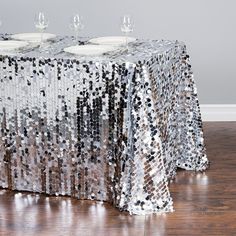 a table covered in sequins with wine glasses sitting on top of the table