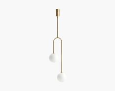 two white balls hanging from a brass colored light fixture on a white wall with no one in it