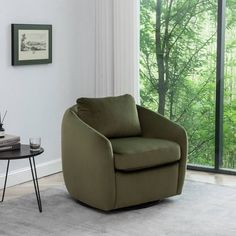 a living room with a large window and a chair next to a small coffee table