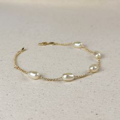 Indulge in the timeless beauty and sophistication of our 18k Gold Filled Spaced Baroque Pearl Bracelet. The perfect blend of elegance and delicacy, this classic piece exudes a luxurious charm that will elevate any outfit. Add a touch of opulence to your wardrobe and captivate with every turn of your wrist. Metal: 18k Gold Filled Width: 10mm Simulated Baroque Pearl Beads Size: 6.5 + 1 inch adjustment. Hypoallergenic Water-resistant Handcrafted in Brazil Hand Chain Bracelet, 18k Gold Chain, Jewelry Lookbook, Hand Chain, Emerald Jewelry, Anklet Jewelry, Earrings Collection, Baroque Pearls, Chain Link Bracelet