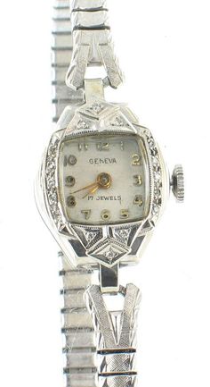 VINTAGE GENEVA 14K WHITE GOLD .O8CT DIAMONDS LADIES WATCH WITH ORIGINAL BOX Offered here is a very pretty deco watch from Geneva. The case is made of 14k white gold and the bezel of the piece contains sixteen .005ct white round diamonds set against a lovely and ornate Art Deco background. The dial features raised number markers and a domed crystal. The case measures about 27mm x 16mm and is beautifully dainty and shiny. The back of the case is stamped with 14K. The band attached is a stretch sty Art Deco Background, Vintage Watches Women, Round Diamond Setting, Pyrex Vintage, Ladies Watch, Wrist Watches, Geneva, Silver Watch, Round Diamonds