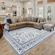 a living room with a large sectional couch in the center and an area rug on the floor