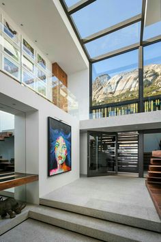 a large painting is hanging on the wall next to some stairs in a modern house