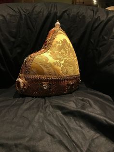 The Doge Hat is the headdress worn by the Doges of Venice and carried over a white cap, similar to the papal camauro, an annual gift of the nuns of San Zaccaria. Composed of a circular crown and a pointed cap in the back, the ducal horn resembled the Phrygian cap worn by Byzantine soldiers and the Venetian dux in ancient times. It was carried, but in a smaller form than that of the Doge, also to crown the golden veil of the Dogaressa, his consort. Over time the various ducal horns have been embe Vintage Ceremonial Costume Hat With High Crown, Traditional Ceremonial Headpiece With Pinched Crown, Ceremonial Tall Crown Headpiece For Festivals, Traditional Handmade Costume Hats And Headpieces, Traditional Gold Cap Hat, Traditional Festival Costume Headpieces, Traditional Ceremonial Headpiece With High Crown, Traditional Headpieces For Costume Festivals, Traditional Costume Hat With Structured Crown