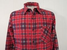 "Vintage 1970s shirt. Made of blue and red plaid cotton flannel. Features a button front, chest pocket and button cuffs. Label is missing. Size large. Actual measurements are: 45\" around the chest, 44\" at the waist, 19\" shoulder seam to shoulder seam, 24\" shoulder seam to end of cuff, 30\" overall length. In excellent unused condition. New old stock." Plaid Cotton Flannel Shirt With Placket, Retro Collared Cotton Flannel Shirt, Retro Cotton Collared Flannel Shirt, Vintage Flannel Button-up Shirt, Vintage Plaid Cotton Shirt, Vintage Plaid Shirt With Pockets, Retro Collared Flannel Shirt With Pockets, Retro Cotton Flannel Shirt For Winter, Vintage Plaid Flannel Shirt With Pockets