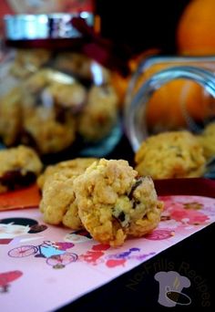 two cookies sitting on top of a table next to an orange and some other food